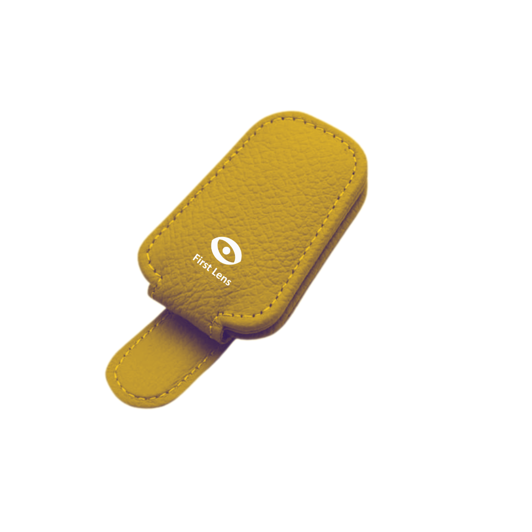 Close-up of First Lens Magnetic Sunglasses Holder with sunglasses clipped in place on a car visor